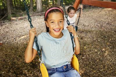 Children Swinging on Yellow belt swing on Wood Playset